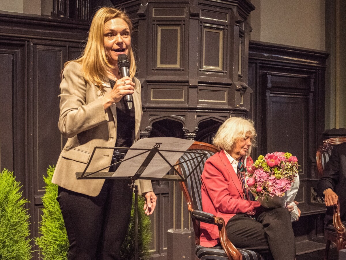 Sabine Claus spricht zu den Teilnehmern der Hohenegg Gespräche, Verena Kast hält Blumenstrauss in der Hand