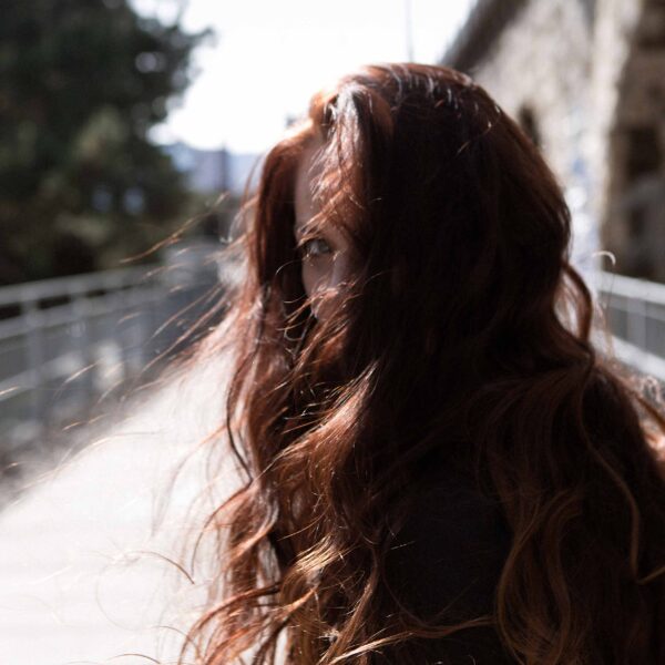 Frau versteckt sich hinter ihren Haaren