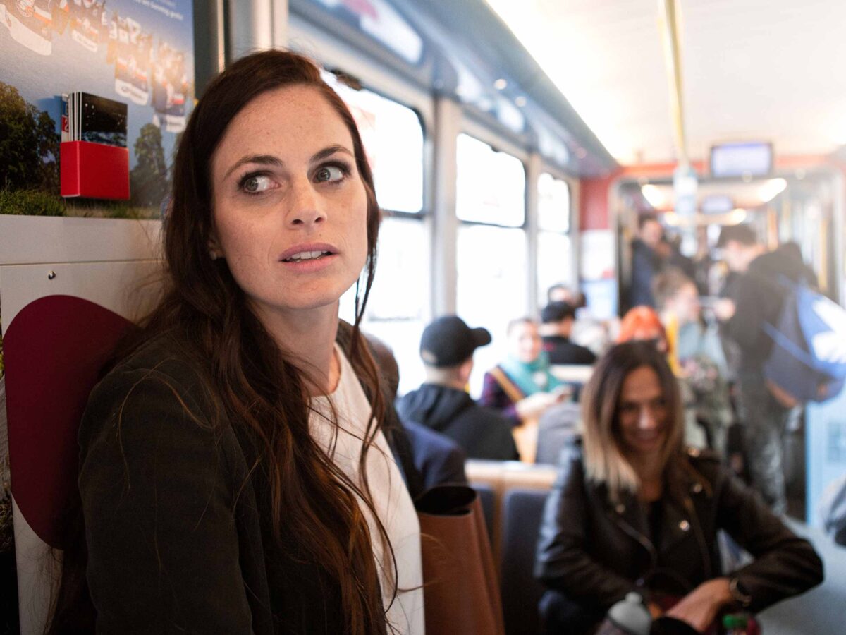 Frau steht im Tram und schaut ängstlich um sich