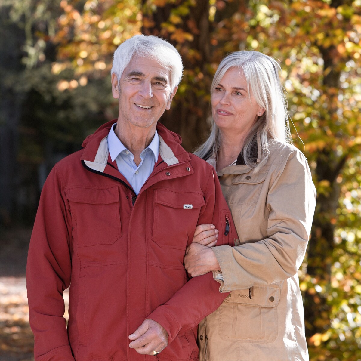 Glückliches, älteres Paar beim Spazieren im Wald