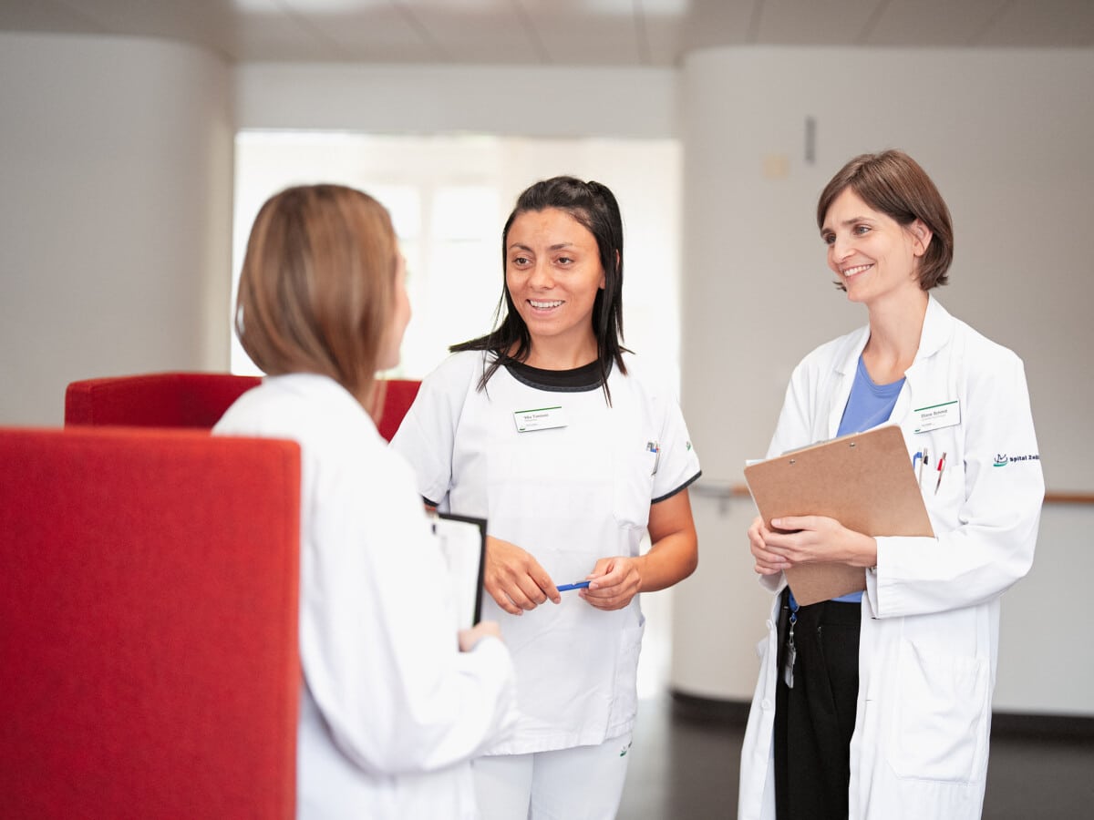 Drei Mitarbeiterinnen des Spital Zollikerbergs im Gespräch im Gang